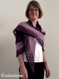 side view of woman wearing large black and purple shawl